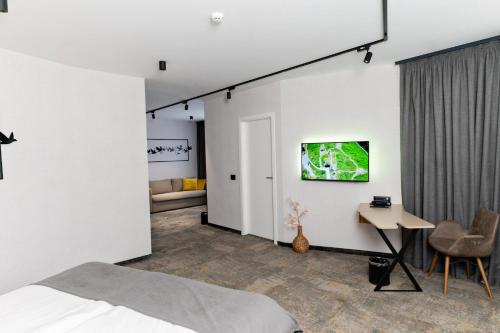 布尔加斯MM Boutique Hotel的卧室配有一张床,墙上配有电视。
