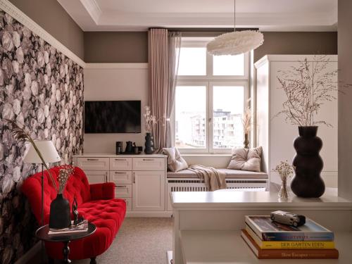 诺德奈1884 Norderney的客厅配有红色椅子和窗户