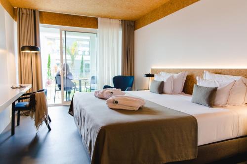 蓬塔德尔加达Canadiano Urban Nature Hotel的酒店客房设有两张床和一个阳台。