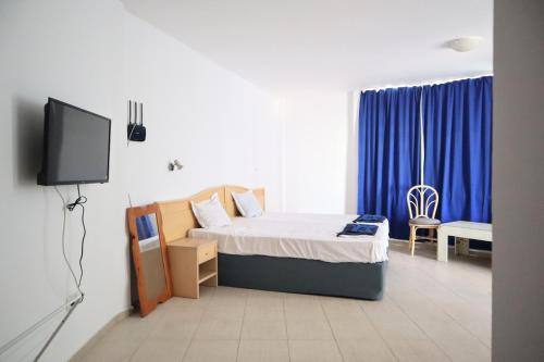 阳光海滩Къща за гости "Arawana"的一间卧室配有一张床和一台电视。