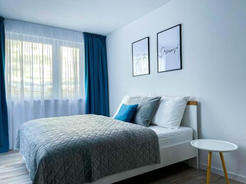 波普拉德LAWIS Apartments的一间卧室配有一张蓝色墙壁的床和一扇窗户