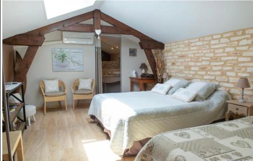 PlazacLe Moulin de Mayence的一间卧室设有两张床和砖墙