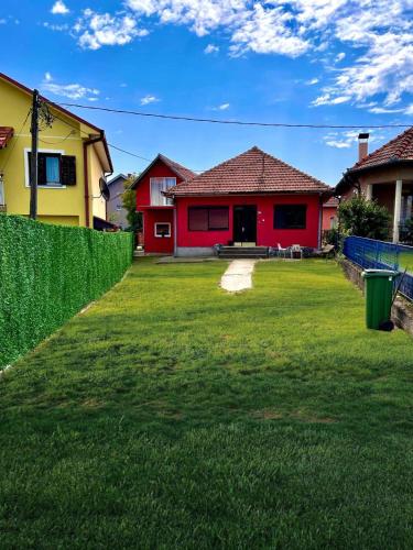 克拉列沃Apartman K3的一座红色的房子和一座黄色的房子,有院子