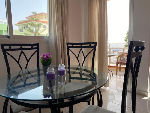 拉斯加莱塔斯Seaside apartment with balcony的客厅里设有玻璃桌和椅子