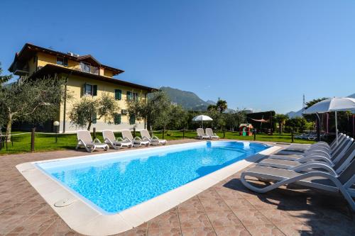 阿科Agritur Girasole的一个带躺椅的游泳池以及一座房子