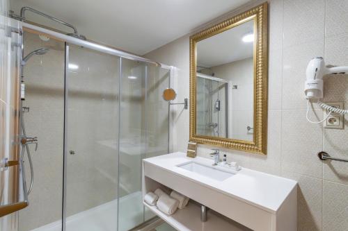 巴塔拉Hotel Lis Batalha的带淋浴、盥洗盆和镜子的浴室