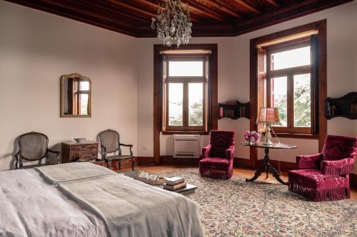卡斯卡伊斯Chalet Ficalho的一间卧室配有一张床、椅子和吊灯