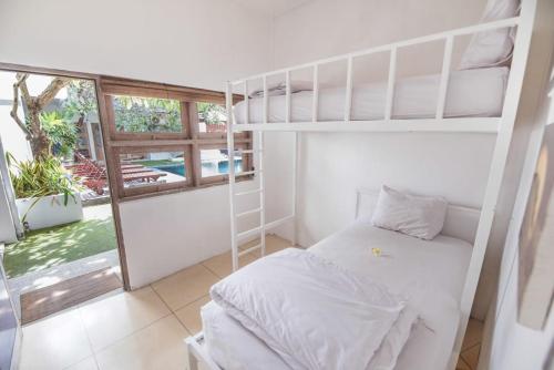 塞米亚克The Island Bali的一间卧室设有两张双层床和一扇窗户。