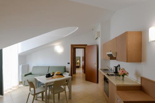 迪亚诺马里纳Hotel & Apartments Sasso的厨房以及带桌椅的起居室。