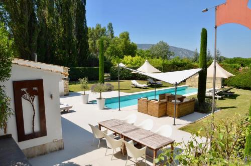 奥佩德LASUITE Domaine Bertuli, heated Pool, Aircon的一个带桌椅的庭院和一个游泳池