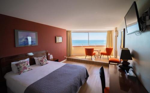 勒阿弗尔LOGIS HOTEL - La Petite Rade的一间卧室配有一张床,享有海景