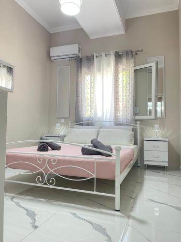 爱琴娜岛Aiginetan Apartments的一间卧室配有一张粉红色框的大床