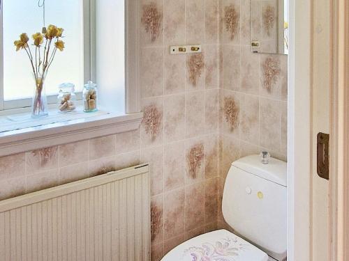 于斯达尔Holiday home LJUSDAL IV的浴室设有卫生间、窗户和花瓶。