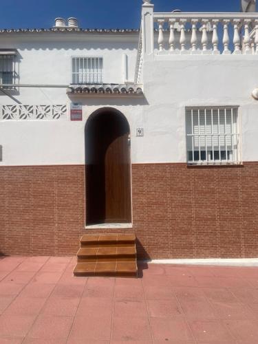 马拉加Malaga Chalet en Guadalmar的前面有门和楼梯的建筑