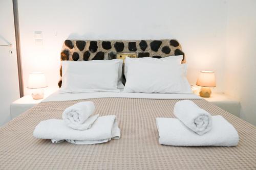卡马利Villa Maina的一间卧室配有带毛巾的床