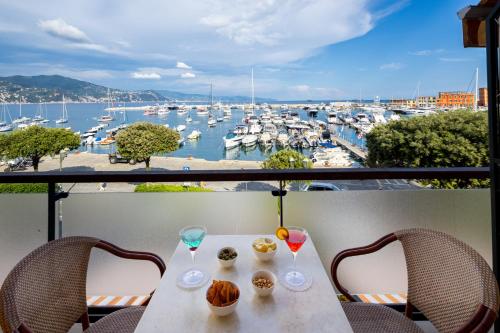 圣玛格丽塔-利古雷劳林酒店的一张桌子,上面放着饮料,享有海港的景色