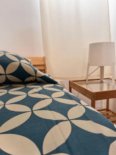滨海波利尼亚诺Dimora dei Pellegrini 8的一张带蓝色和白色毯子的床和一张桌子