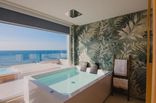 托雷圣乔万尼乌Parco dei Principi - Resort & Spa的带浴缸的浴室和大窗户