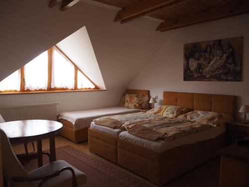 利普托斯基米库拉斯Privat Alenka的一间卧室设有两张床、一张桌子和窗户。