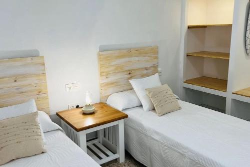法马拉Famara Frontsea house的一间卧室设有两张床和一张木桌