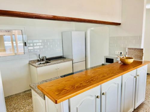 法马拉Famara Frontsea house的厨房配有白色橱柜和木制台面