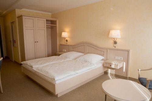 博德卢姆Landhaus Sterdebüll的卧室配有白色的床和桌子