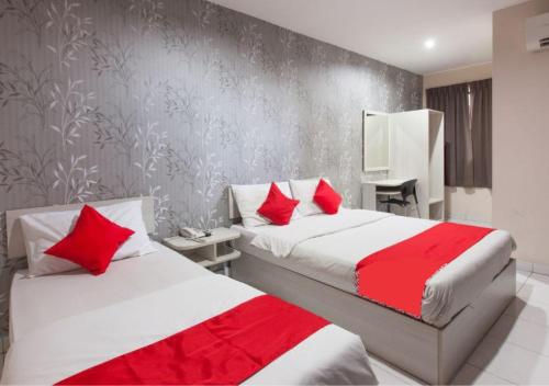 怡保Hotel Pulai Ipoh的一间卧室配有两张带红色枕头的床