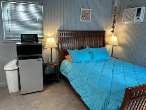 SargentSeagull Seaclusion的一间卧室配有一张带蓝色床单的床和一台笔记本电脑