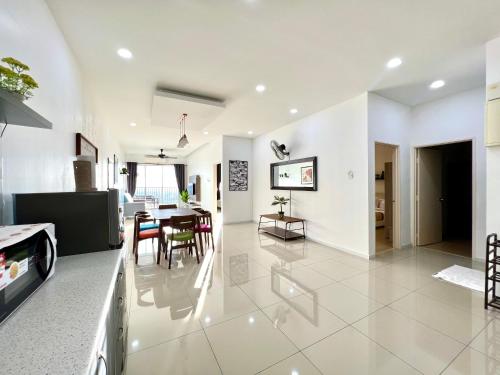 太平Home Away From Home In Taiping - Newly Upgraded!的厨房以及带桌椅的起居室。