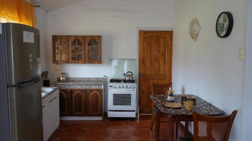 安加罗阿复活节岛露营度假屋的厨房配有炉灶和桌椅
