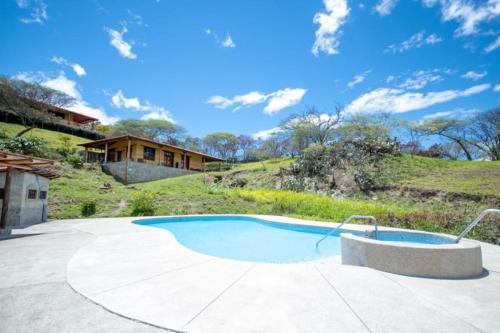 洛哈Vilcabamba casa / granja Vilcabamba house / farm的一座带房子的庭院内的游泳池