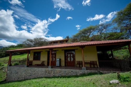 洛哈Vilcabamba casa / granja Vilcabamba house / farm的红色屋顶的黄色小房子
