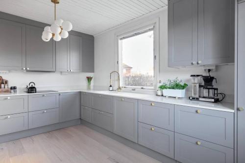 斯德哥尔摩Amazing family home in Stockholm的白色的厨房配有白色橱柜和窗户