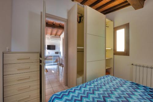 阿祖罗港La Casina di Alan - Goelba的一间卧室配有一张床,一扇门通往厨房