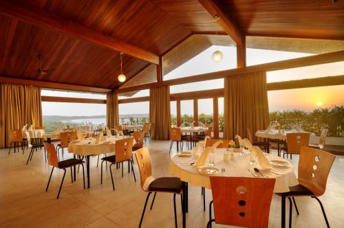 帕纳吉海滨露台酒店的用餐室设有桌椅和窗户。