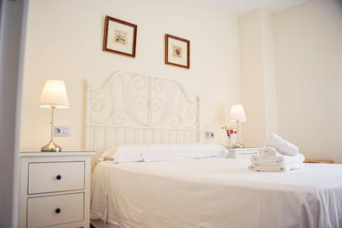 塞维利亚Ramón y Cajal by TheGoodTourist的白色卧室配有一张白色大床和两盏灯