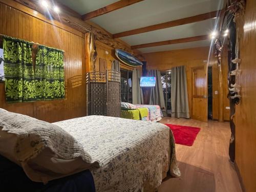安加罗阿Ihirani的卧室配有一张床铺,位于带木墙的房间内