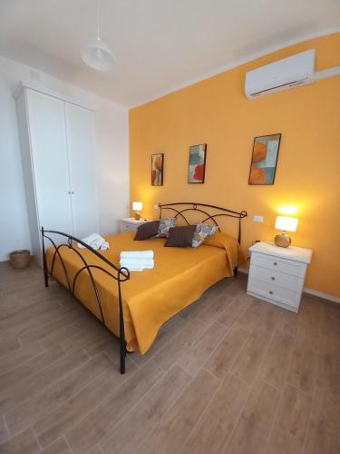 古斯皮尼Divina Cuspide的一间卧室设有一张床和黄色的墙壁