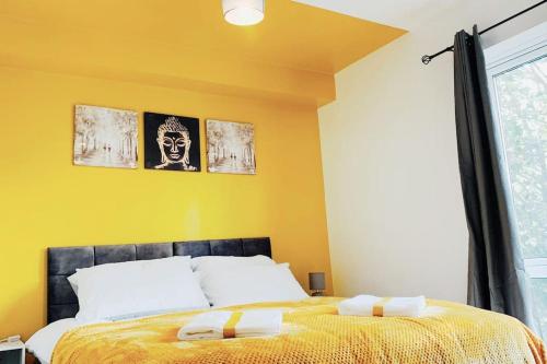 切姆2 Bed Apartment with Free Parking的一间卧室设有一张床和黄色的墙壁