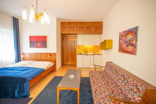 沃尔特湖畔佩莎赫Villa Gabriela的一间卧室配有一张床和一张沙发,还设有一间厨房