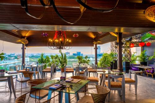 浦那O Hotel Pune的一间设有桌椅的餐厅,享有美景。