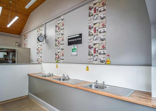 Enfield LockLee Valley Sewardstone的浴室设有两个盥洗盆,墙上挂有图片