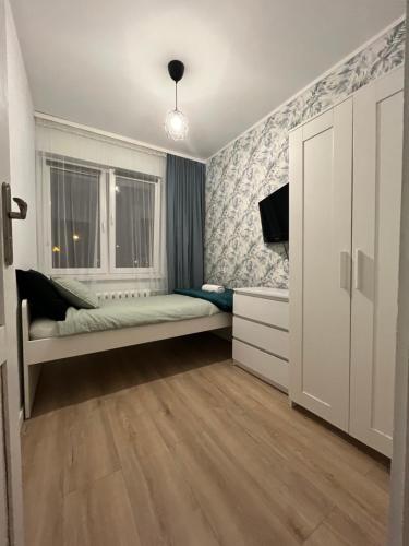 格丁尼亚Apartament Revel的一间小卧室,配有床和窗户