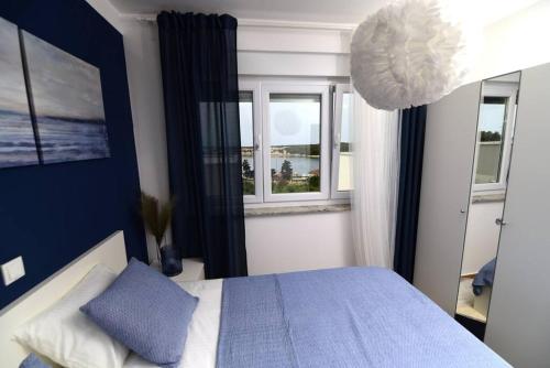 伊穆尼Apartman Eva的卧室配有蓝色和白色的床和窗户。