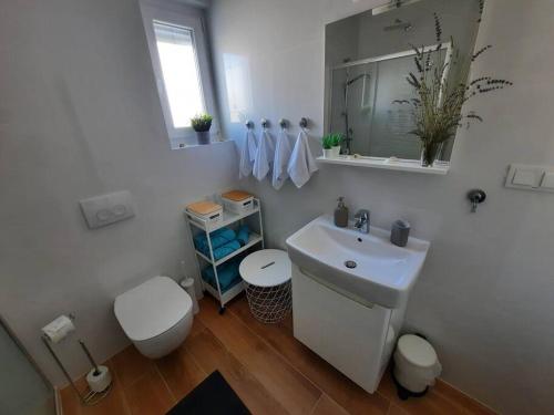 伊穆尼Apartman Eva的白色的浴室设有卫生间和水槽。