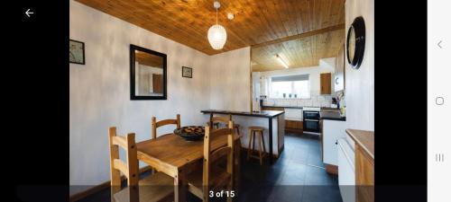 Golden ValleyHome in Cheltenham的厨房以及带木桌和椅子的用餐室。
