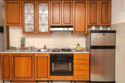 拉巴克Apartment Nia的厨房配有木制橱柜和不锈钢冰箱。