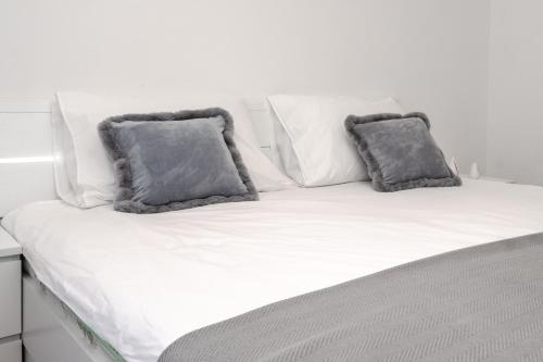 拉巴克Apartment Nia的一张白色的床,上面有两个灰色的枕头