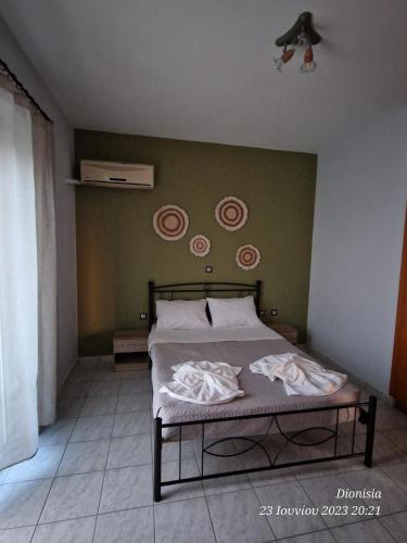 科斯镇FILIANTHI的一间卧室设有一张床和绿色的墙壁