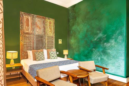 里约热内卢Selina Lapa Rio de Janeiro的一间卧室配有一张床、两把椅子和一幅画